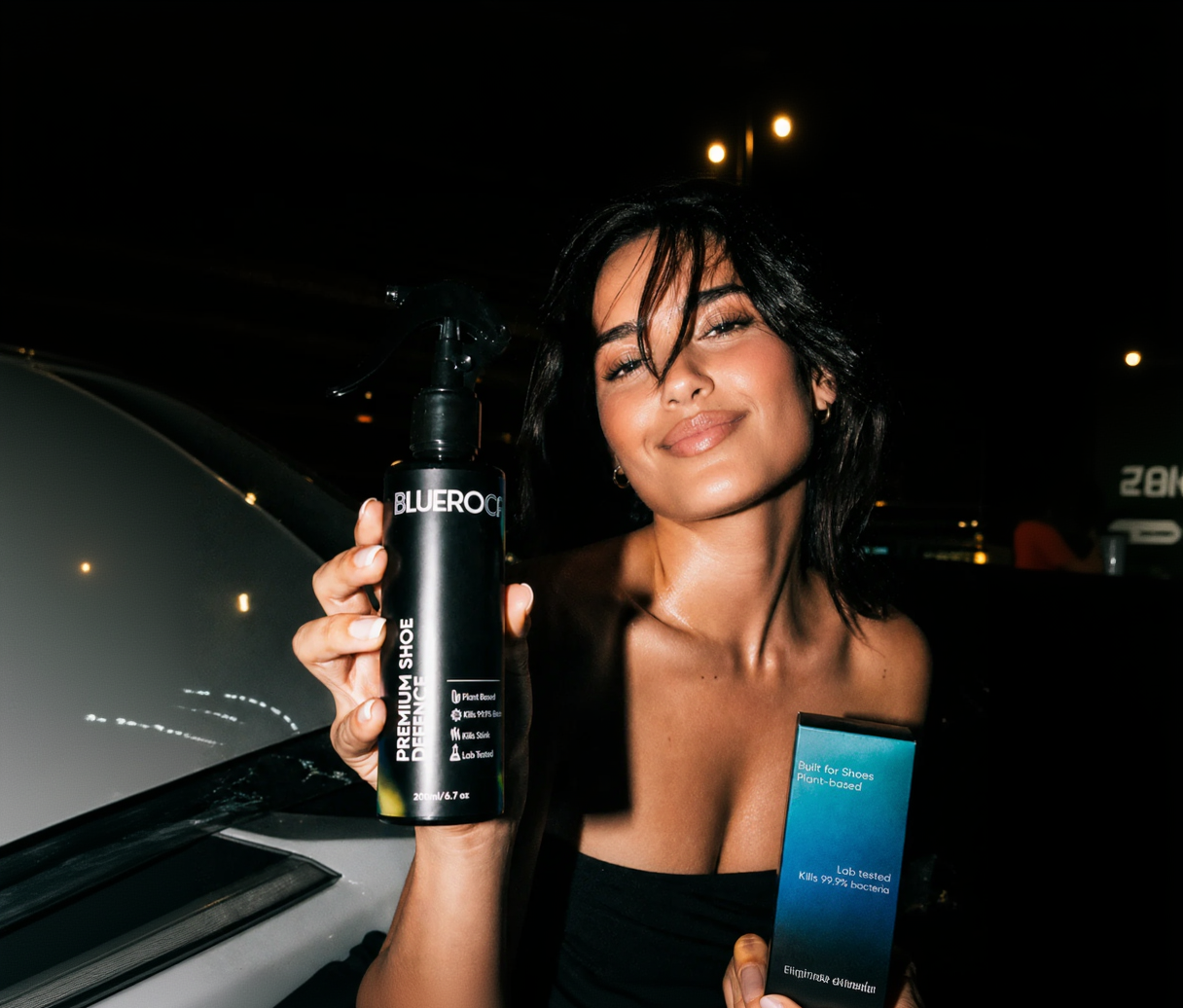 Woman holding a BLUEROCA shoe defense product at night. a SHOE DEODORISER AND A SHOE DISINFECTANT 
